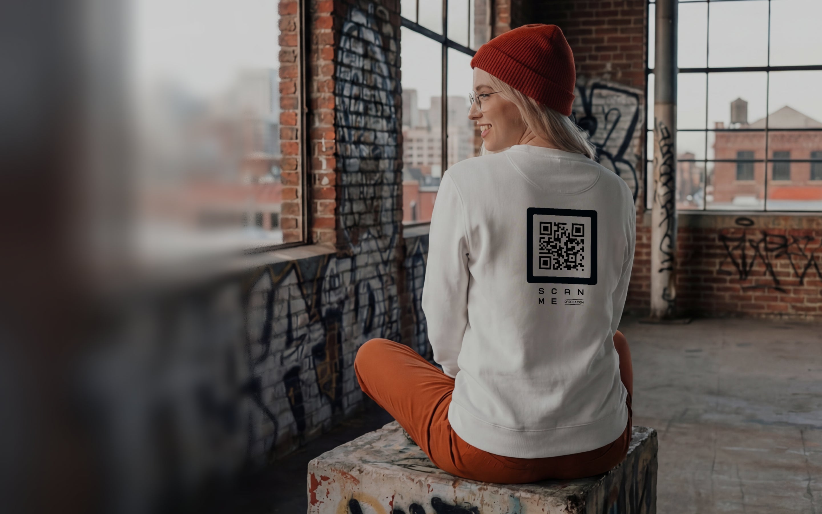 Woman in white sweatshirt with QR code on back. Streetwear photo, graffiti, old warehouse