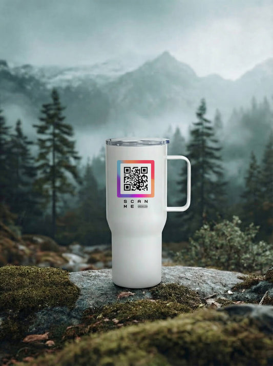 White travel mug with colorful QR code, outdoors among moss, rocks, and pine trees